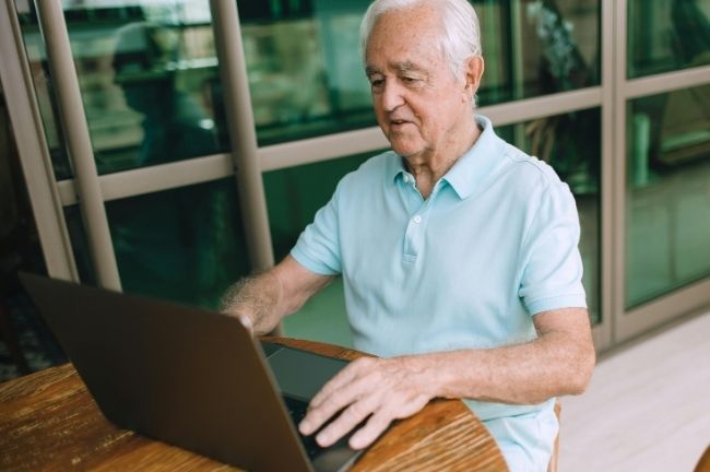 An older gentlemen uses the assessment calculator on his laptop.