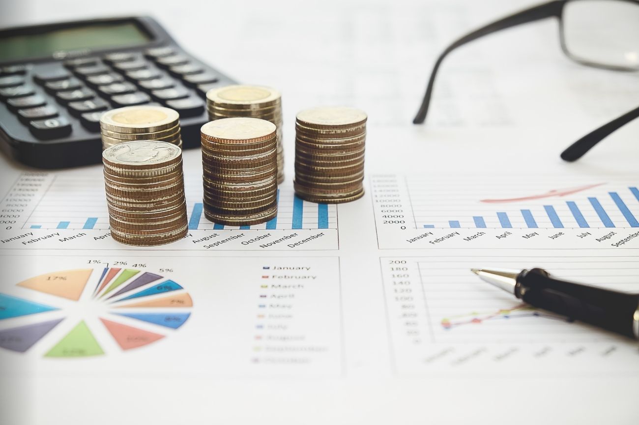 Graphs, coins, and a calculator symbolising managing finacnes.