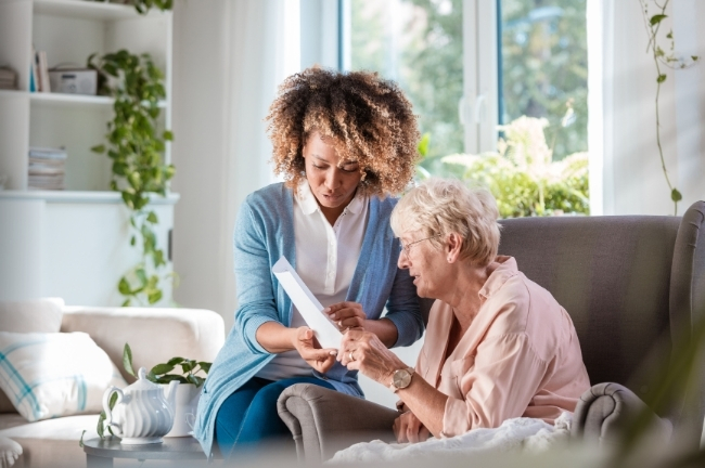 Support worker discussing a support plan with a lady in her living room.