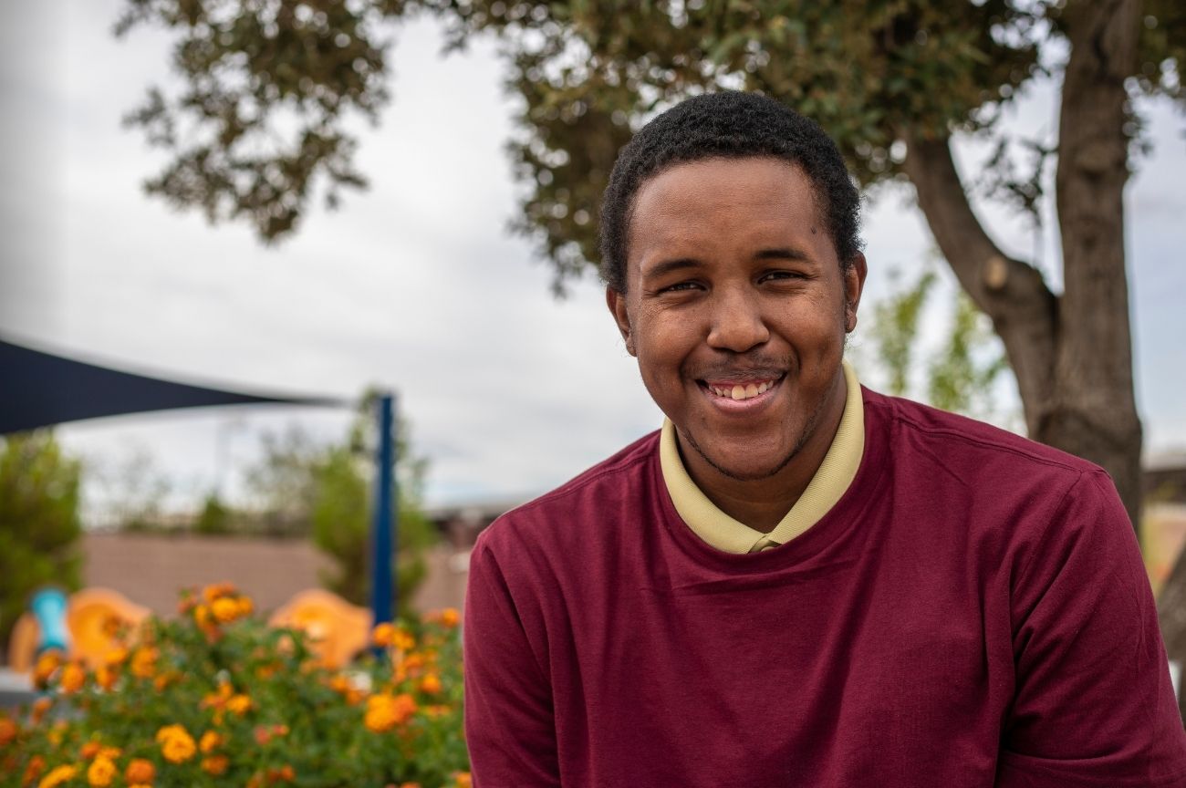 Young man smiles, knowing we will support him to become an employer.